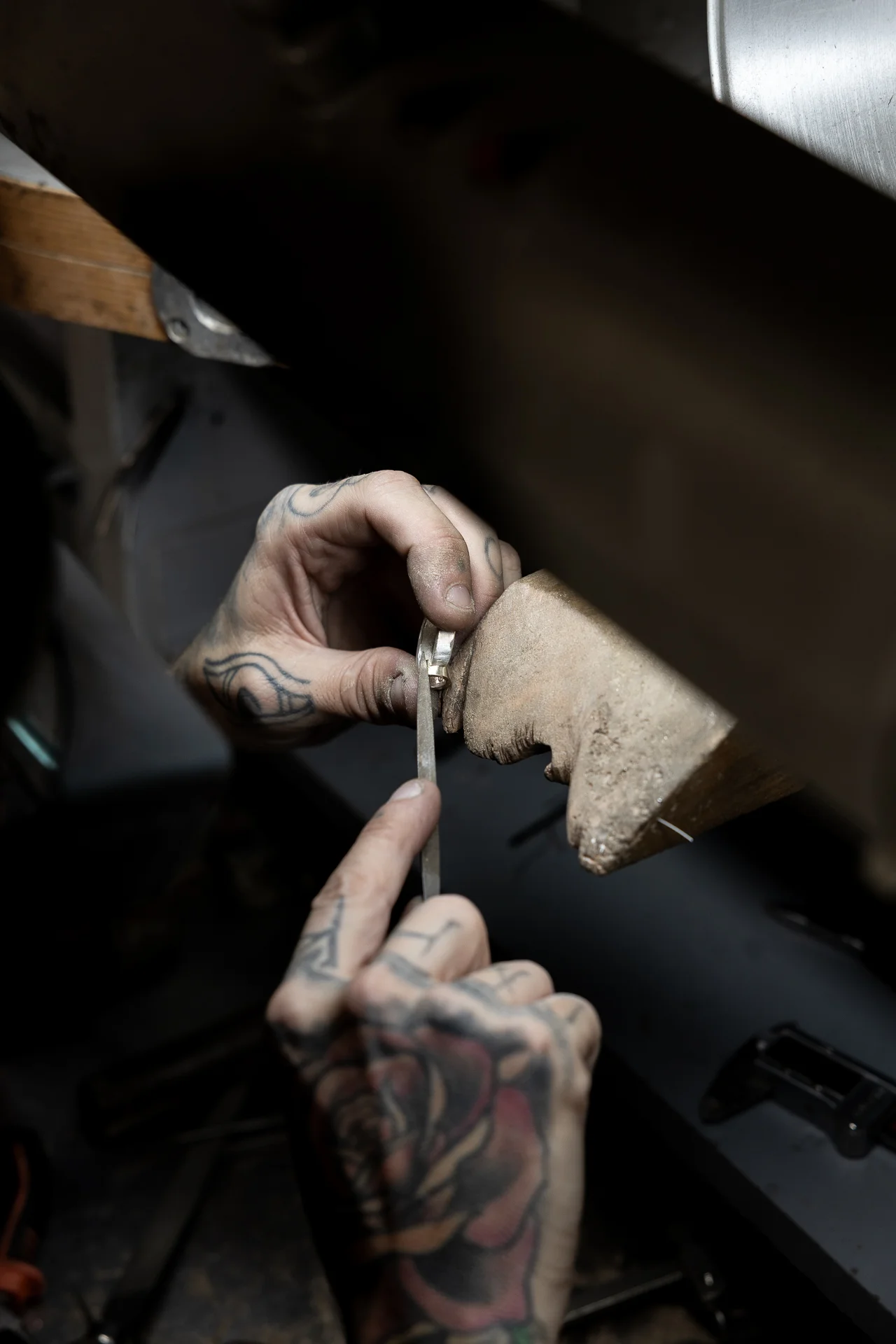 Orafo rifinisce a mano un anello con lima durante la fase di lavorazione artigianale