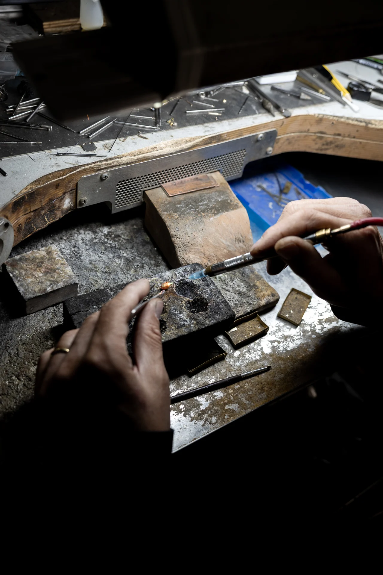 Orafo mentre salda un gioiello in oro con cannello nel laboratorio artigianale