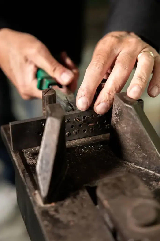 Mani di orafo al lavoro su metallo